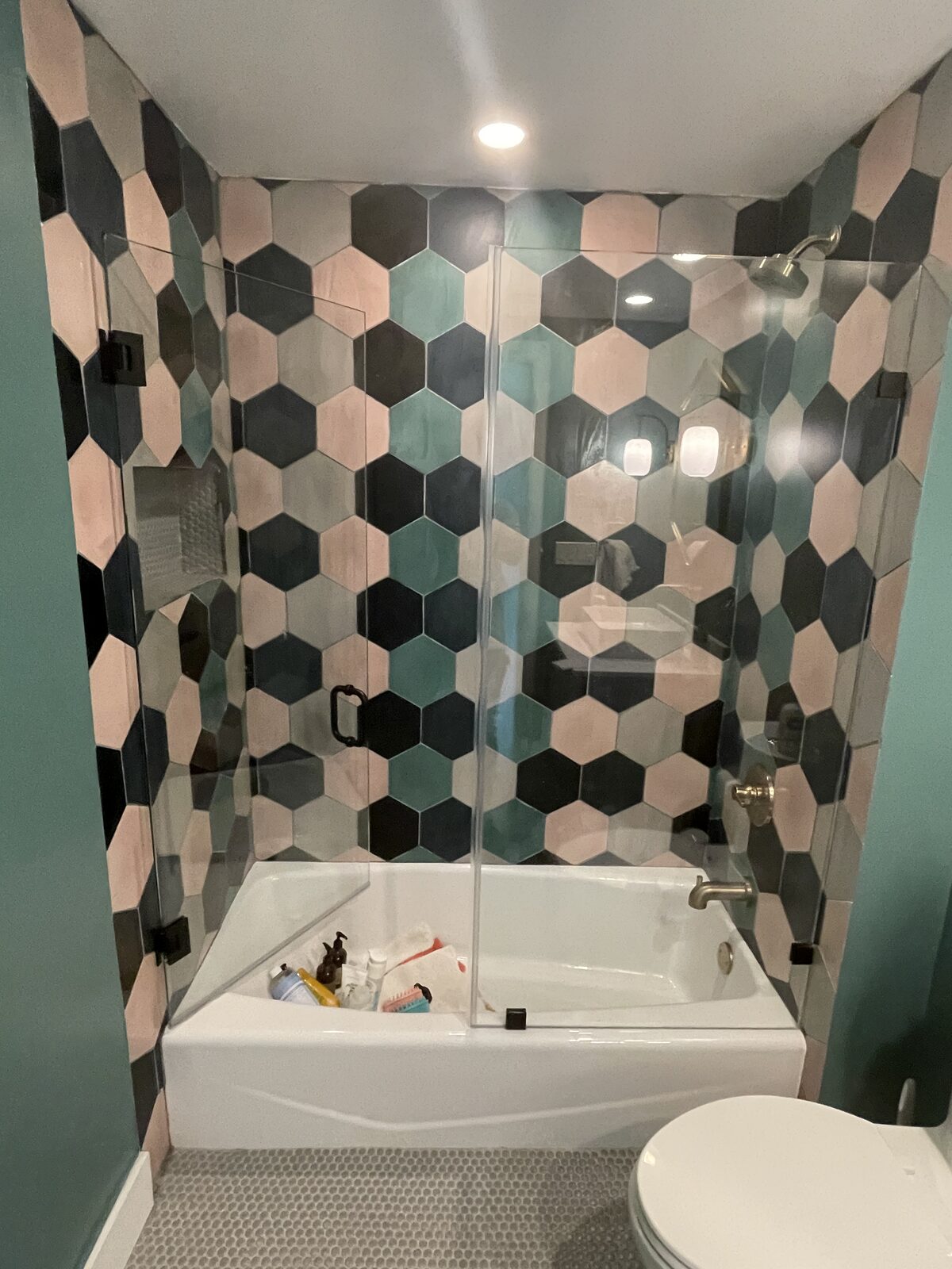 Bathroom with hexagonal tile shower in pink, teal and black